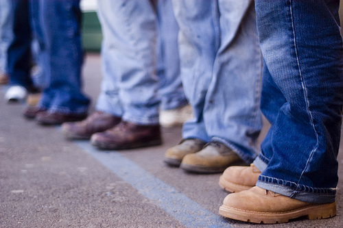 group of people from the knees down wearing jeans and boots