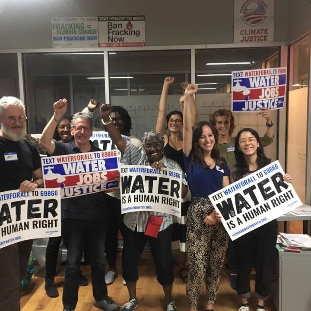 a group of people holding signs advocating that water is a human right