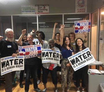 a group of people holding signs advocating that water is a human right