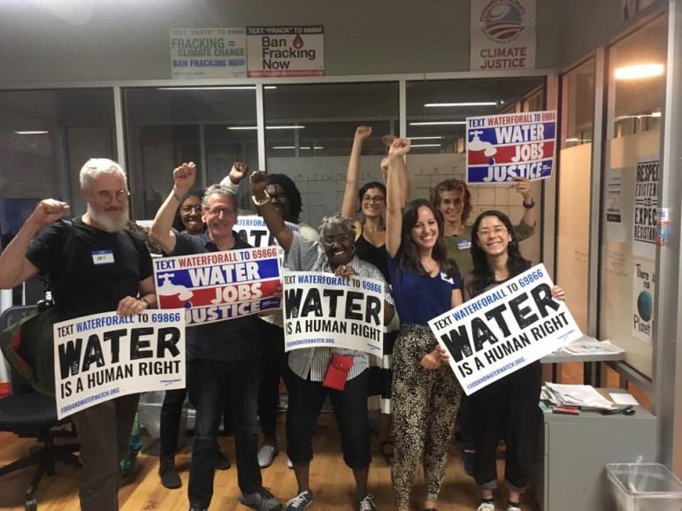 a group of people holding signs advocating that water is a human right