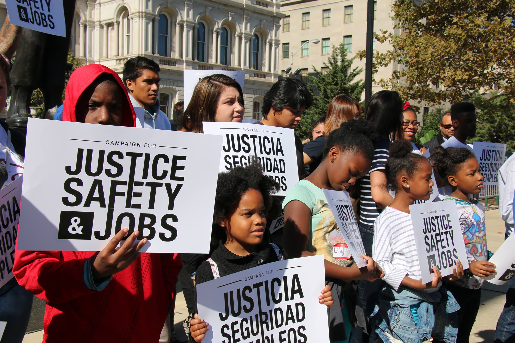 activists holding signs that say justice safety and jobs