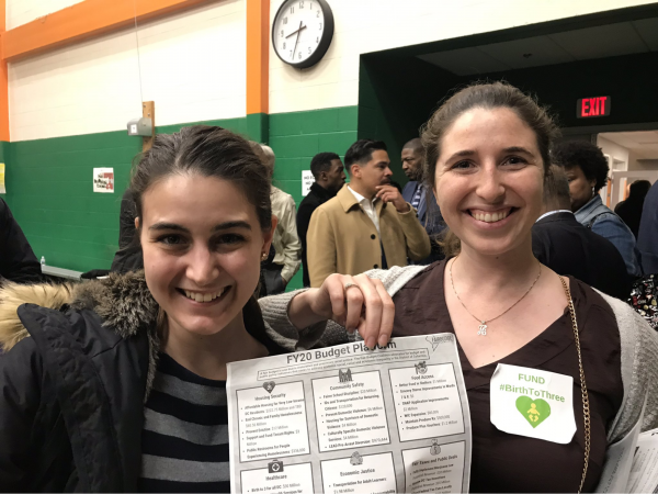 smiling young women hold a FY20 budget plan
