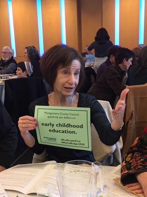anita lampel holds a sign