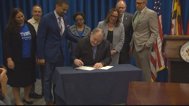 man signing bill