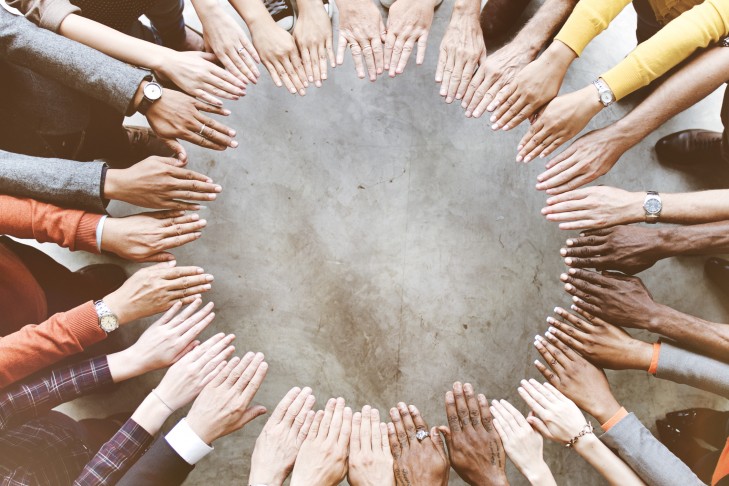 A circle of hands of many races.
