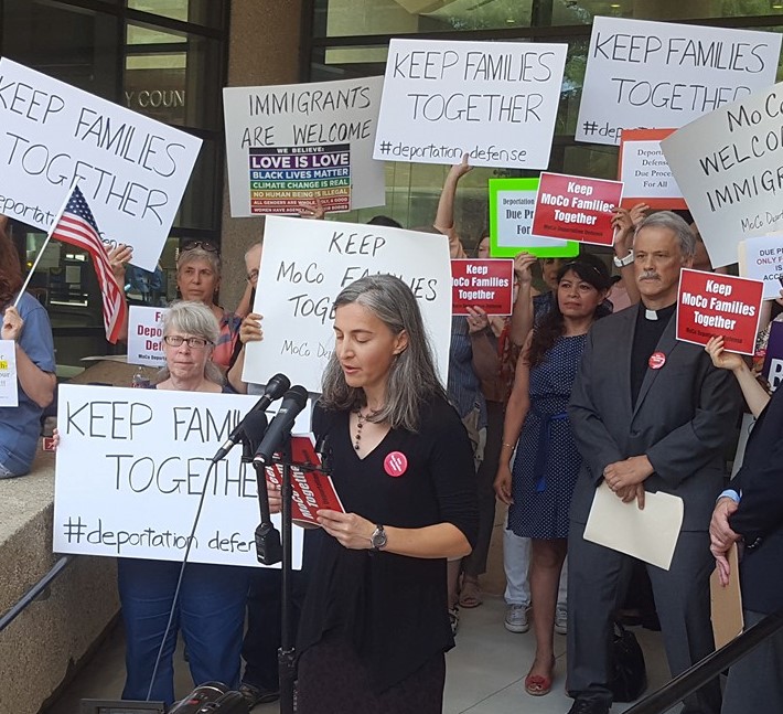 protesters holding signs supporting immigration justice