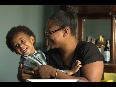 smiling woman holding a smiling toddler