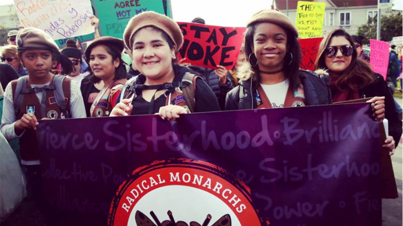Young women protesting with radical monarchs