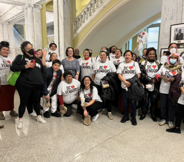 A crowd of street vendors and campaign partners wearing "DC heart vendors" shirts