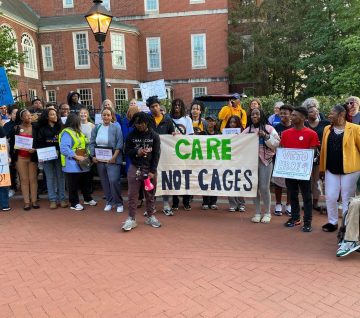 JUFJ and our partners holding up signs advocating for youth justice and "Care, not Cages"